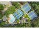Aerial view of community pool, tennis courts, and clubhouse nestled among lush trees in a residential neighborhood at 9595 Rod Rd, Alpharetta, GA 30022