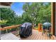 A spacious wooden deck offers an outdoor cooking area with covered grill and a view of the private backyard at 9595 Rod Rd, Alpharetta, GA 30022