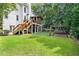 The expansive backyard features lush grass, mature trees, a cozy porch, and play equipment, perfect for outdoor activities at 9595 Rod Rd, Alpharetta, GA 30022