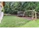A well-maintained backyard features lush green grass, play equipment, and mature trees, creating a private outdoor retreat at 9595 Rod Rd, Alpharetta, GA 30022