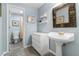 Bright bathroom with a pedestal sink, modern vanity, and decorative mirror at 9595 Rod Rd, Alpharetta, GA 30022