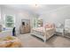 Bright bedroom features neutral walls, a floral comforter and decorative dresser with mirror near the window at 9595 Rod Rd, Alpharetta, GA 30022