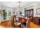 Formal dining room with hardwood floors, large windows, and elegant chandelier at 9595 Rod Rd, Alpharetta, GA 30022
