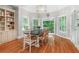 Dining area with large windows offering natural light, a wooden table, and built-in bookshelves at 9595 Rod Rd, Alpharetta, GA 30022