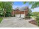 This brick home features a three-car garage and a well-manicured lawn, offering charm and functionality in a desirable location at 9595 Rod Rd, Alpharetta, GA 30022