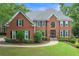 Traditional two-story brick home with manicured lawn and mature landscaping creates great curb appeal at 9595 Rod Rd, Alpharetta, GA 30022