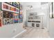 Hallway with decorative artwork, light hardwood floors, and white storage cabinets at 9595 Rod Rd, Alpharetta, GA 30022