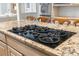 Close-up of kitchen island cooktop with granite countertops at 9595 Rod Rd, Alpharetta, GA 30022