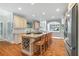 Open kitchen design with an island, cooktop, wine rack, and stainless refrigerator, flowing into the dining area at 9595 Rod Rd, Alpharetta, GA 30022