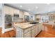 Bright kitchen with a large center island with cooktop, stainless appliances, and custom cabinets at 9595 Rod Rd, Alpharetta, GA 30022