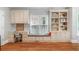 Home office with built-in bookshelves, cabinetry, desk space, window seat, and hardwood floors at 9595 Rod Rd, Alpharetta, GA 30022