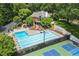 Aerial view of a community pool and tennis courts, surrounded by trees and a lounge area at 9595 Rod Rd, Alpharetta, GA 30022
