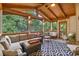 Inviting screened porch features wood ceiling, decorative rug, and comfortable seating for relaxation and outdoor enjoyment at 9595 Rod Rd, Alpharetta, GA 30022