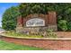 Brick entrance sign for Chartwell community, framed by colorful flowers and small American flags, creating a welcoming scene at 9595 Rod Rd, Alpharetta, GA 30022