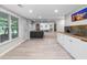 Open-concept wet bar featuring a tiled countertop and view into the living room and backyard at 9595 Rod Rd, Alpharetta, GA 30022