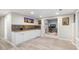 Basement wet bar area with white cabinets, tiled backsplash, and light-colored flooring at 9595 Rod Rd, Alpharetta, GA 30022