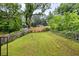 Spacious backyard featuring a mix of manicured lawn and natural growth, enclosed with wooden and chain link fences at 1268 Ladd Sw St, Atlanta, GA 30310