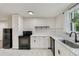 Modern kitchen features white cabinetry, black appliances, and a subway tile backsplash at 1268 Ladd Sw St, Atlanta, GA 30310