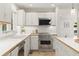 Bright kitchen features white cabinets, wood trim, stainless steel appliances and plenty of natural light at 1678 Rabke Rd, Canton, GA 30114