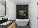 Bathroom showcasing soaking tub with a black marble tile backdrop and modern fixtures at 178 Wesley Ne Ave # B, Atlanta, GA 30307