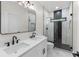 Modern bathroom featuring double sinks, sleek black fixtures, and a glass-enclosed shower with unique tiling at 178 Wesley Ne Ave # B, Atlanta, GA 30307