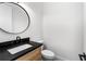 Stylish half bath with a modern vanity, black countertop, round mirror and toilet at 178 Wesley Ne Ave # B, Atlanta, GA 30307