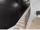 Stylish staircase featuring light wood steps, a black railing, and an elegant black accent wall at 178 Wesley Ne Ave # B, Atlanta, GA 30307