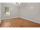 Minimalist bedroom featuring hardwood floors and a bright window offering serene views at 3357 Saddleton Way, Douglasville, GA 30134