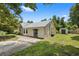 Home with light yellow siding, gray metal roof, shed, and spacious lawn at 3357 Saddleton Way, Douglasville, GA 30134