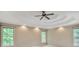 Spacious bedroom featuring tray ceiling, ceiling fan and view from the double windows at 4990 Sawgrass Nw Pl, Acworth, GA 30102