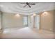 Large bedroom with trey ceiling, ceiling fan, neutral walls, and two white doors at 4990 Sawgrass Nw Pl, Acworth, GA 30102