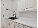 Laundry room with white cabinets, marble countertops, and a black faucet at 4990 Sawgrass Nw Pl, Acworth, GA 30102
