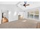 Spacious and bright living room with a ceiling fan, large windows, and a bar at 4990 Sawgrass Nw Pl, Acworth, GA 30102