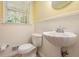 Charming powder room featuring a pedestal sink, classic fixtures, and wainscoting, offering a cozy space at 1703 W Nancy Creek Ne Dr, Brookhaven, GA 30319