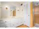Bathroom featuring vanity with cabinets, large mirror, sconce lighting and tiled shower at 1703 W Nancy Creek Ne Dr, Brookhaven, GA 30319