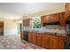 Well-lit kitchen featuring wooden cabinets, tile countertops, and checkered flooring, offering functionality at 1703 W Nancy Creek Ne Dr, Brookhaven, GA 30319