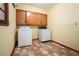 Functional laundry room featuring a washer, dryer, built-in cabinets, and durable tile flooring at 1703 W Nancy Creek Ne Dr, Brookhaven, GA 30319