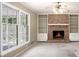 Living room with brick fireplace, built-in shelves, ceiling fan and large windows at 1703 W Nancy Creek Ne Dr, Brookhaven, GA 30319