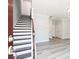 Open entryway featuring wood stairs with black risers, light gray walls, and light wood flooring at 2971 Beaconwood Ct, Lawrenceville, GA 30043