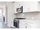 Stylish kitchen features stainless steel appliances, white cabinets and tile backsplash at 2971 Beaconwood Ct, Lawrenceville, GA 30043