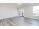 Spacious living room with light gray walls, wood floors, balcony access, and one large window at 2971 Beaconwood Ct, Lawrenceville, GA 30043