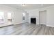 Light filled living room with light gray walls, wood floors, a fireplace, and access to the balcony at 2971 Beaconwood Ct, Lawrenceville, GA 30043