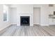 Modern living room with light gray walls, wood floors, a fireplace, and open access to the kitchen at 2971 Beaconwood Ct, Lawrenceville, GA 30043