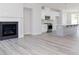 Open concept living room flowing into kitchen with light gray walls, wood floors, and a fireplace at 2971 Beaconwood Ct, Lawrenceville, GA 30043