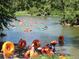 Sunny river scene with many people enjoying the water in colorful inflatable tubes at 3542 Chattahoochee Summit Se Ln, Atlanta, GA 30339