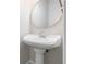 Close-up of the pedestal sink in the powder room, featuring a round mirror at 3774 Seasons Nw Dr, Acworth, GA 30101