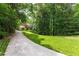 Secluded home nestled among mature trees and lush landscaping with winding driveway and green lawn at 4219 Harrogate Nw Dr, Atlanta, GA 30327