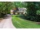 A well-maintained house with a manicured lawn and a concrete driveway, surrounded by mature trees at 4219 Harrogate Nw Dr, Atlanta, GA 30327