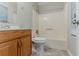 Standard bathroom featuring a toilet, shower-tub combo and vanity with a wood finish at 4905 Sandberg Ct, Stone Mountain, GA 30088