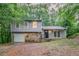 Charming home featuring a stone accent wall, garage, and nestled among mature trees at 4905 Sandberg Ct, Stone Mountain, GA 30088